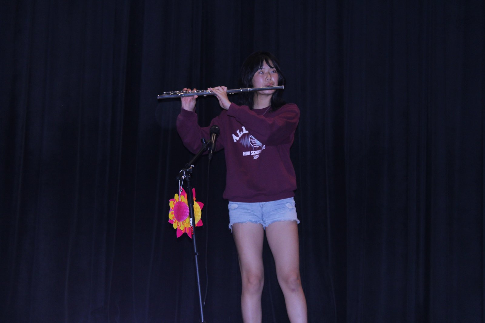 Student performing flute on stage